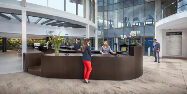 Moderne ontvangsthal van multi-tenant kantoorgebouw aan de Fascinatio Boulevard met receptiebalie en bezoekers.